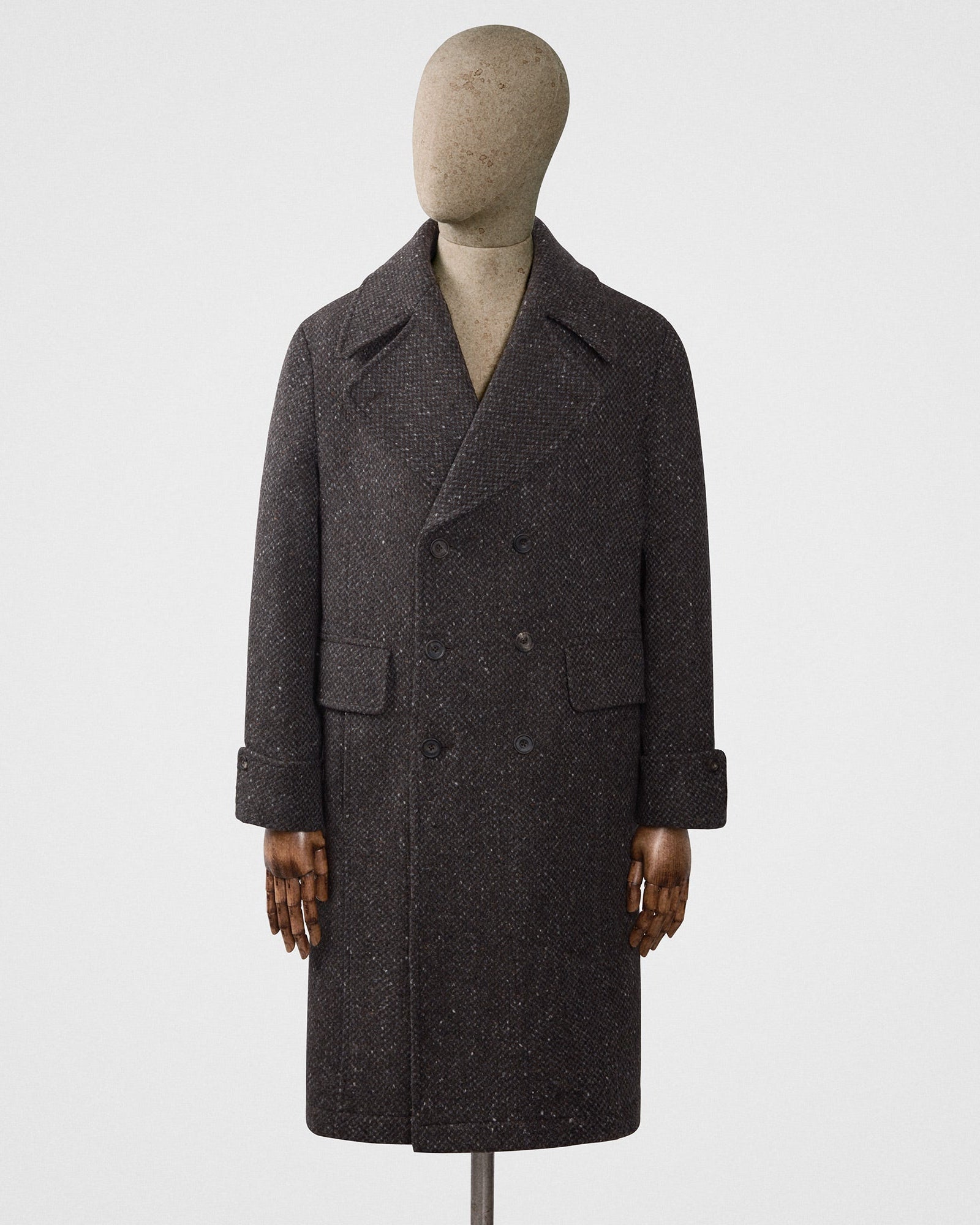 Dark gray coat on a mannequin against a white background